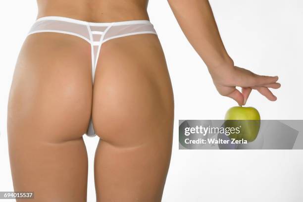 caucasian woman wearing panty holding green apple - thong stock pictures, royalty-free photos & images