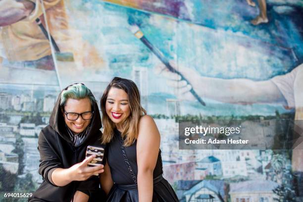 smiling asian women posing for cell phone selfie - oakland california fotografías e imágenes de stock