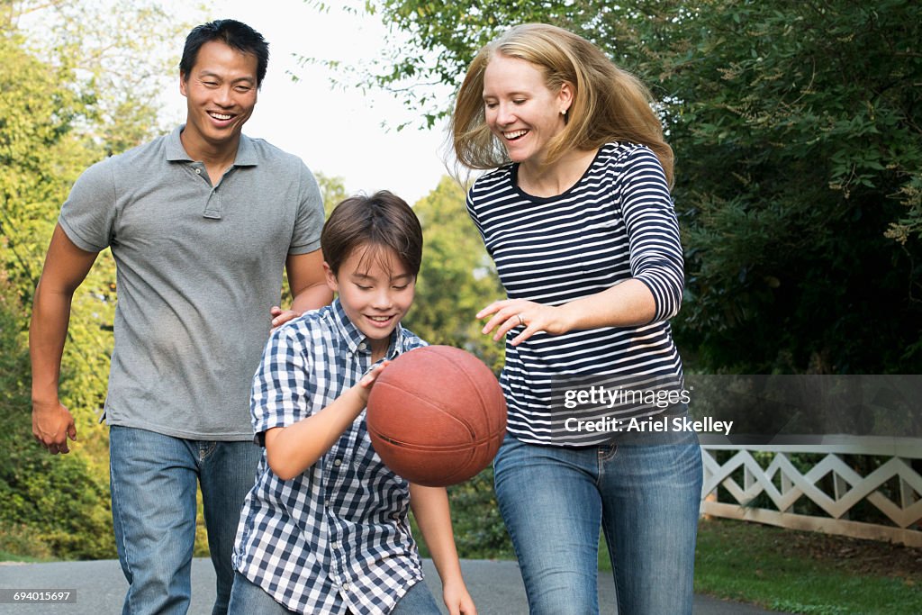 Smiling family playing basketball