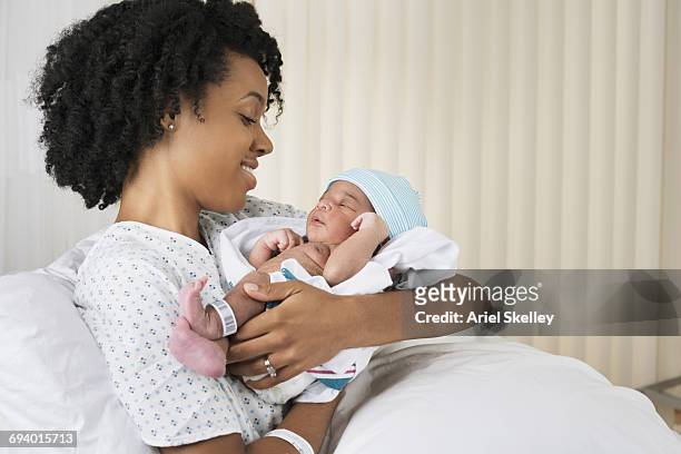 smiling black mother holding newborn baby in hospital - baby name stock pictures, royalty-free photos & images