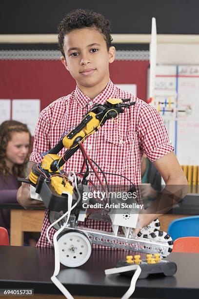 mixed race boy posing with robot in robotics class - school science project stock pictures, royalty-free photos & images