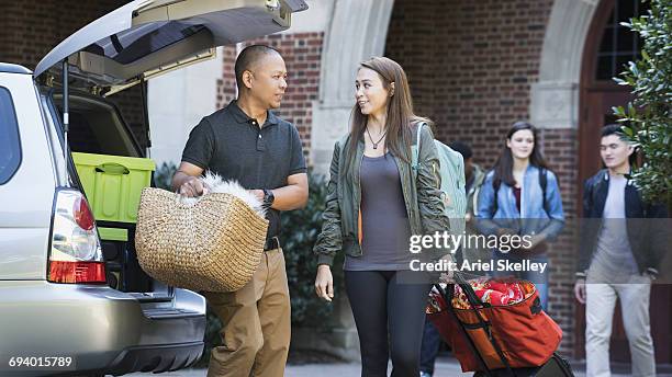 father helping daughter moving to college dormitory - basket universitario imagens e fotografias de stock