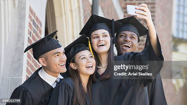 students posing for cell phone selfie at graduation - diverse graduation stock pictures, royalty-free photos & images