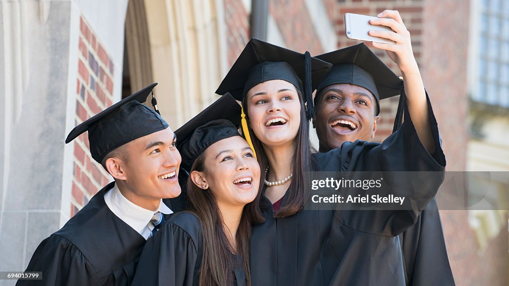 Students posing for cell phone selfie at graduation