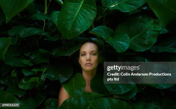 face of pacific islander woman surrounded by wet leaves - pacific islands nature stock pictures, royalty-free photos & images