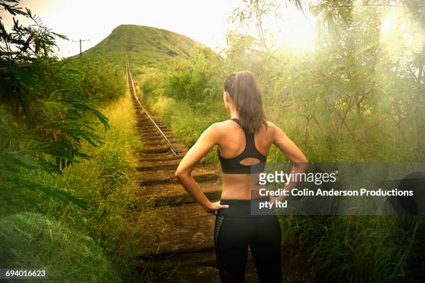 pacific islander woman standing near staircase on hill - forward athlete stockfoto's en -beelden