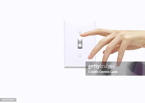 hand of woman pressing light switch - light switch hand stock pictures, royalty-free photos & images