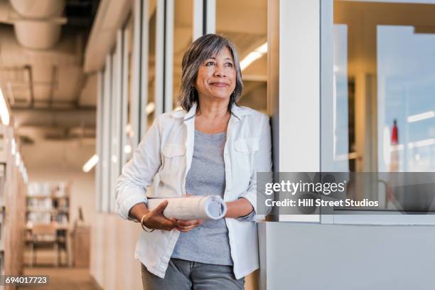 smiling filipino architect carrying blueprints - filipino woman smiling stock pictures, royalty-free photos & images