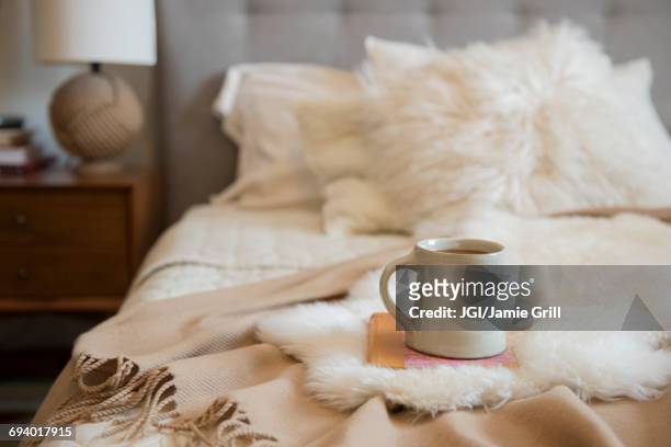 coffee cup and book on fur on bed - filt bildbanksfoton och bilder