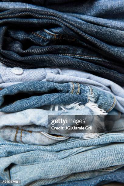 stack of folded blue jeans - denim stock pictures, royalty-free photos & images