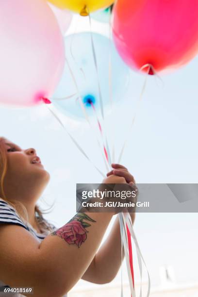 caucasian girl with temporary arm tattoo holding balloons - 臨時 個照片及圖片檔