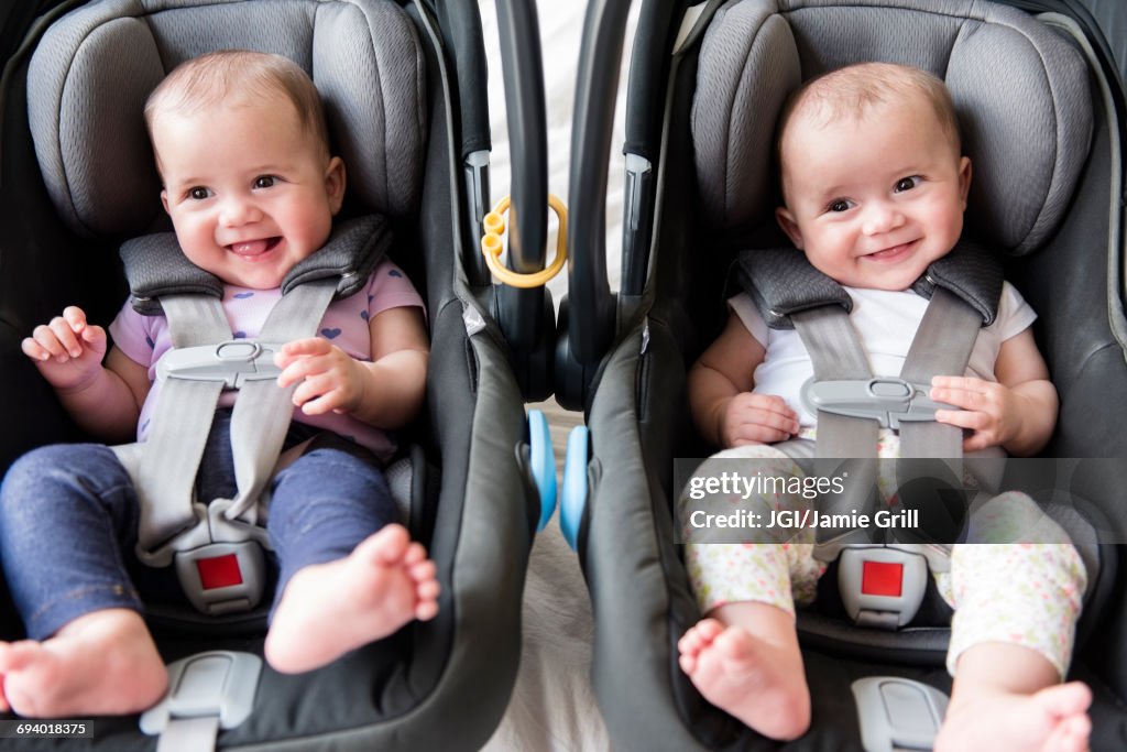 Caucasian twin baby girls in car seats