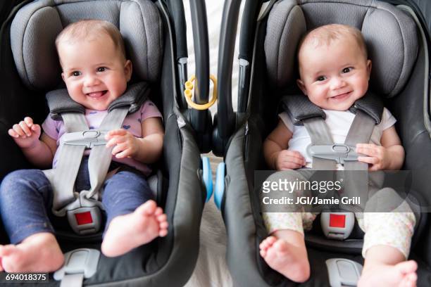 caucasian twin baby girls in car seats - twin stock pictures, royalty-free photos & images