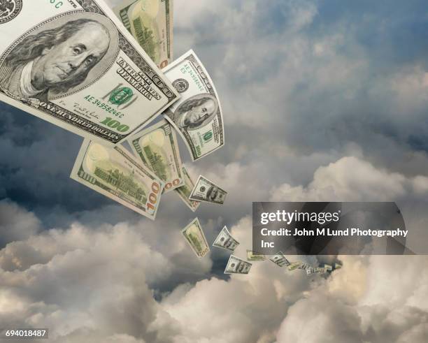 one hundred dollar bills flying in clouds - finance and economy photos stock illustrations