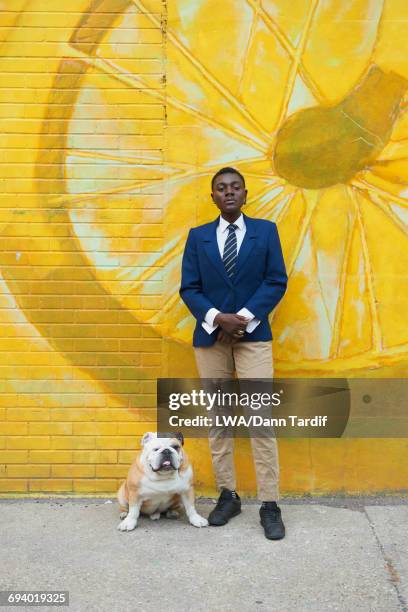 androgynous black woman with dog leaning on mural - black transgender stock-fotos und bilder