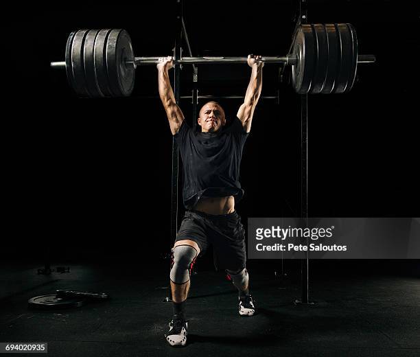 man lifting heavy barbell in gymnasium - weight training stock pictures, royalty-free photos & images
