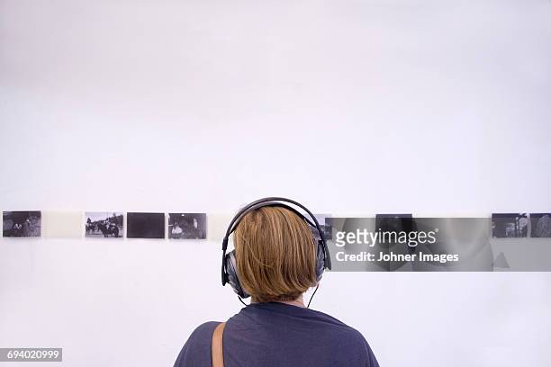 young woman looking at exhibition - exhibitions stock-fotos und bilder