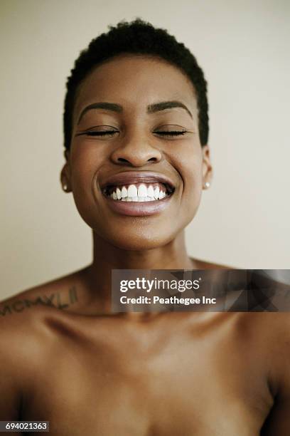 portrait of smiling black woman with eyes closed - woman's chest stock pictures, royalty-free photos & images