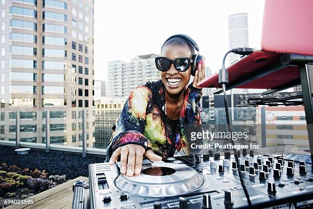 smiling black dj on urban rooftop - dj party stock-fotos und bilder