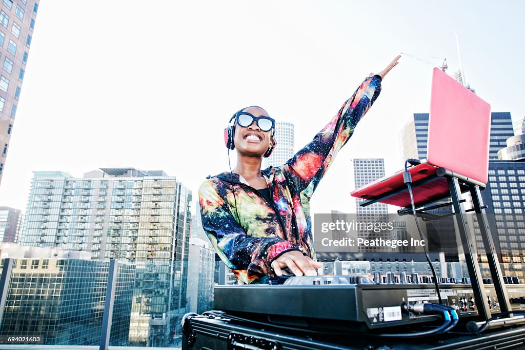 Smiling Black DJ on urban rooftop