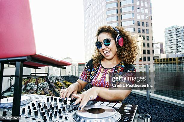 smiling mixed race dj on urban rooftop - dj fotografías e imágenes de stock