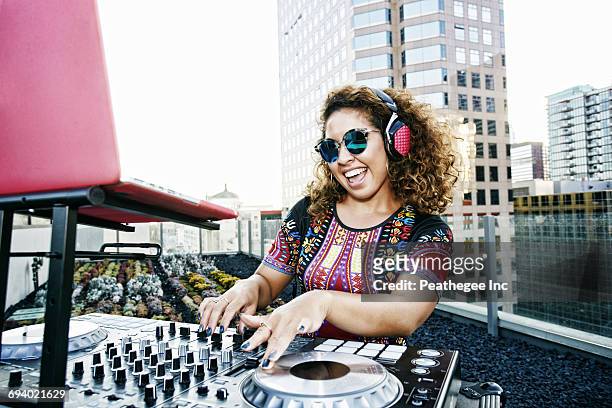 smiling mixed race dj on urban rooftop - dj 個照片及圖片檔