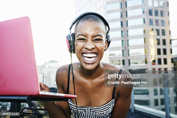 portrait of black dj laughing on urban rooftop - shaved head fotografías e imágenes de stock