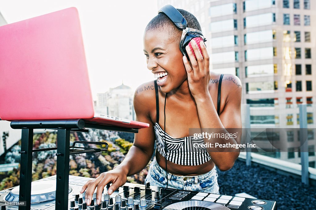 Black DJ laughing on urban rooftop