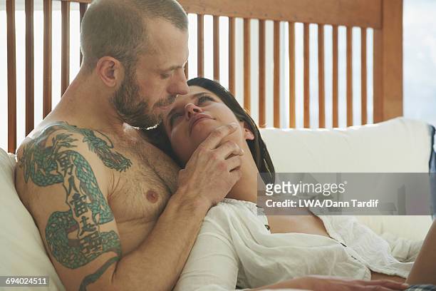 caucasian couple relaxing in bed - white dragon tattoo stock pictures, royalty-free photos & images