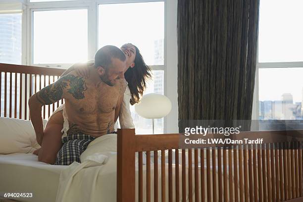 playful caucasian couple kneeling in bed - white dragon tattoo stock pictures, royalty-free photos & images