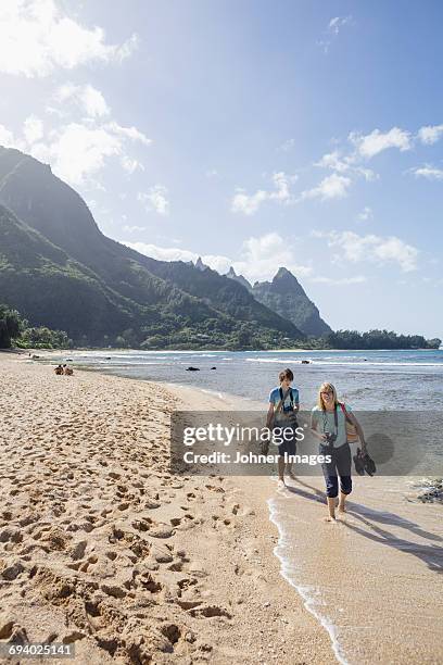 woman with son walking on beach - hawaii vacation and parent and teenager stock pictures, royalty-free photos & images