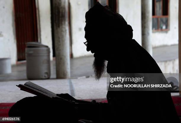 In this photograph taken on June 8 an Afghan resident reads the Quran in a mosque in Jalalabad. Muslims throughout the world are marking the month of...