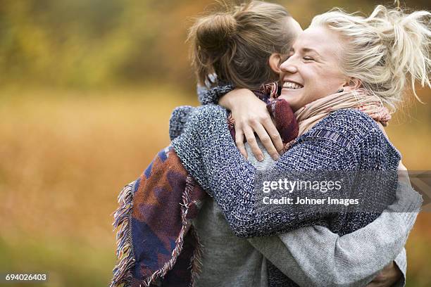 two women hugging - mid adult woman sweater stock pictures, royalty-free photos & images