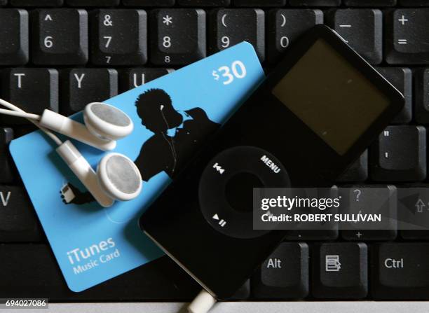 An Apple Nano and ITunes music card on a computer keyboard 07 May 2007, in Miami, Florida. Apple Chief Executive Steve Jobs has opened the door to...