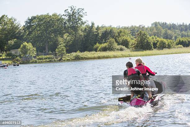 mother and teenage son on jet ski - jet ski stock pictures, royalty-free photos & images