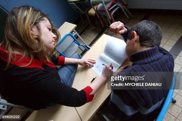 Stéphanie, référente à l'accompagnement scolaire surveille et aide à faire leurs devoirs, le 01 mars 2005, un groupe d'enfants, après les heures de...