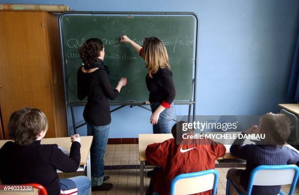 Stéphanie , référente à l'accompagnement scolaire surveille et aide à faire leurs devoirs, le 01 mars 2005, un groupe d'enfants, après les heures de...