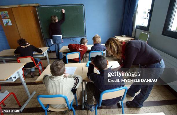 Stéphanie , référente à l'accompagnement scolaire surveille et aide à faire leurs devoirs, le 01 mars 2005, un groupe d'enfants, après les heures de...