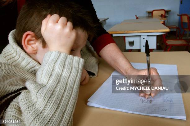 Stéphanie, référente à l'accompagnement scolaire surveille et aide à faire leurs devoirs, le 01 mars 2005, un groupe d'enfants, après les heures de...