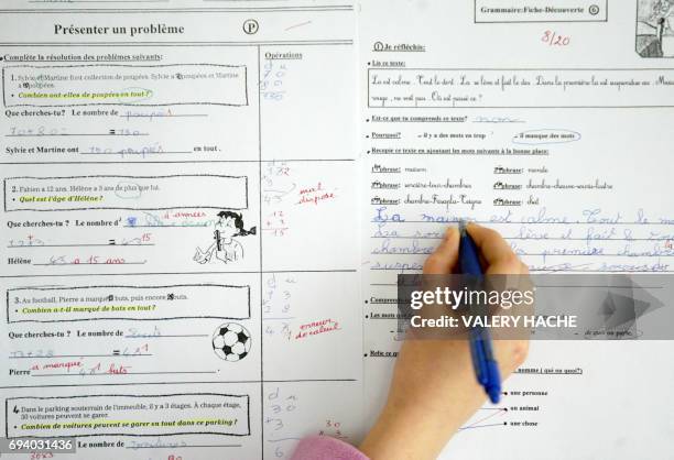 Une éleve de cours moyen corrige ses devoirs notés par son institutrice, le 10 février 2005 à Rennes. Les principales associations de parents...