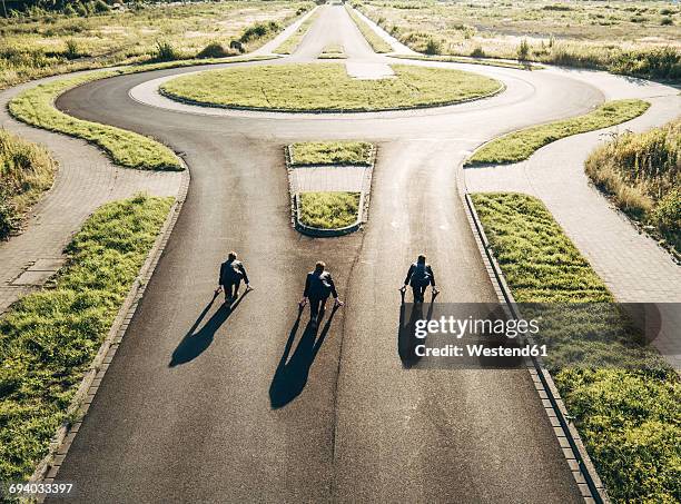three businessmen starting race at roundabout - championship round three stock-fotos und bilder