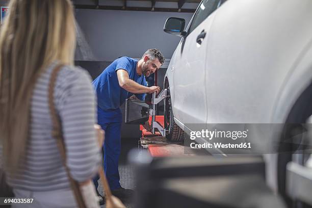 mechanic fitting tyre in workshop - auto repair shop background stock pictures, royalty-free photos & images