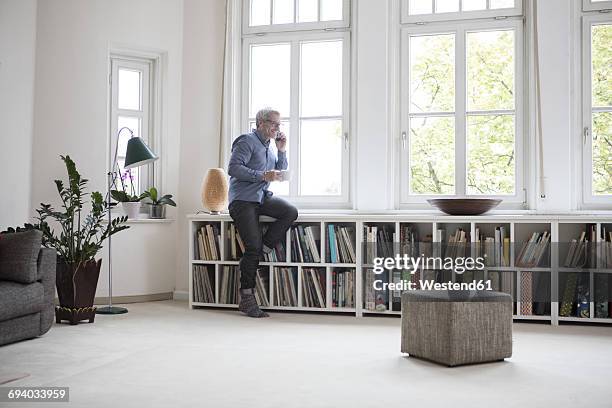 mature man at home on the phone - men wearing stockings stock pictures, royalty-free photos & images