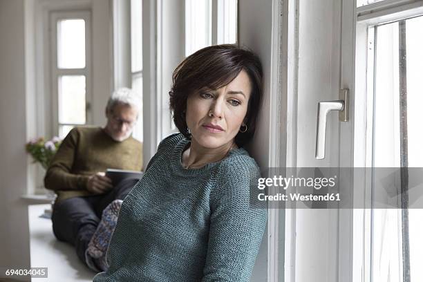 disappointed woman with man in background - woman fighting stock pictures, royalty-free photos & images