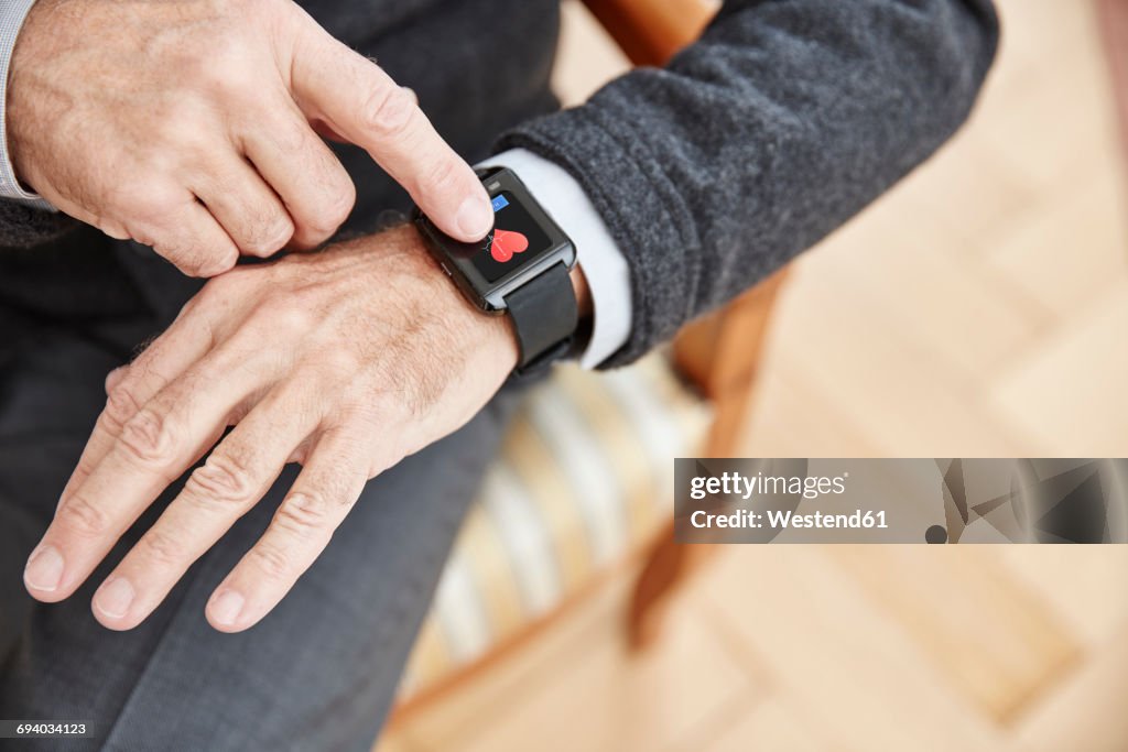 Senior man checking medical data on smartwatch