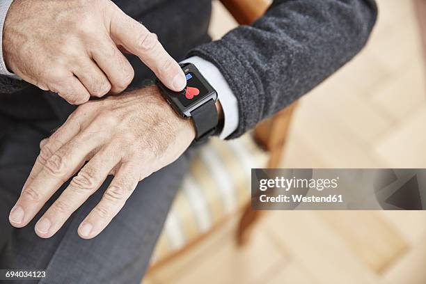 senior man checking medical data on smartwatch - computador utilizável como acessório imagens e fotografias de stock