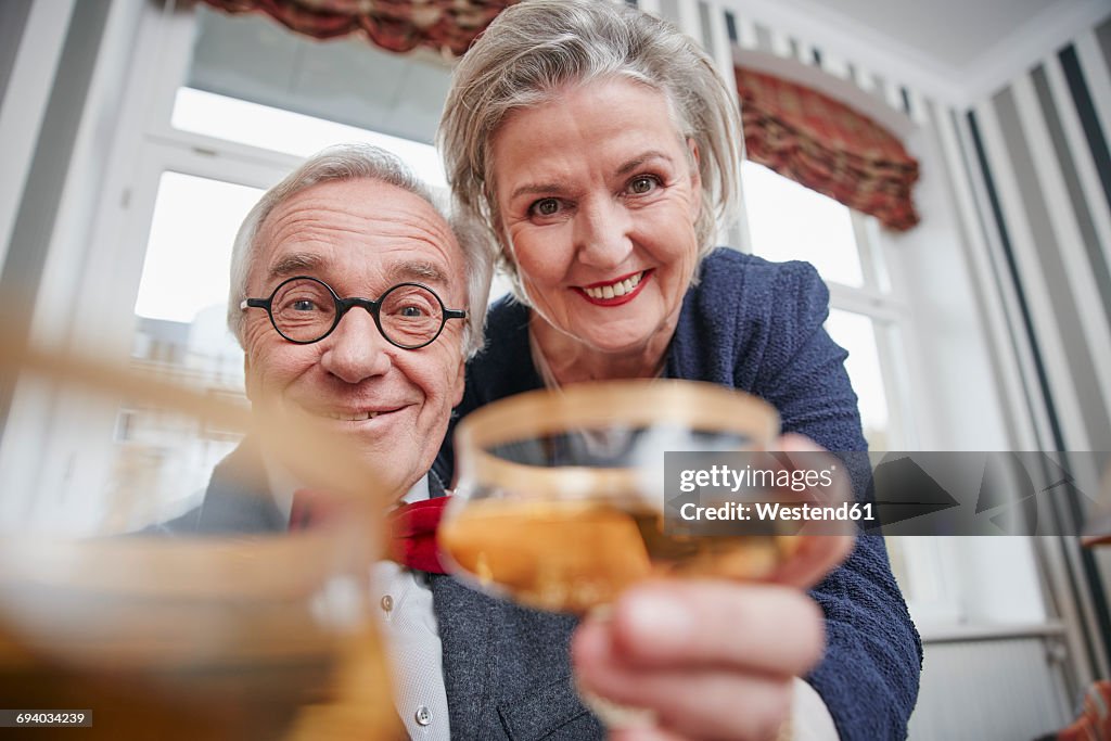 Portrait of happy senior couple holding champagne glasses