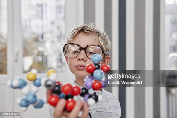 boy wearing oversized glasses looking at molecular model - 科学者　子供 ストックフォトと画像