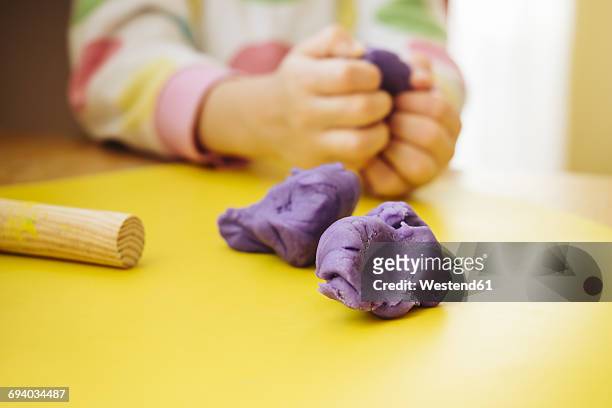 child's hands kneading modelling clay - klei stockfoto's en -beelden