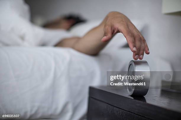 man reaching to turn off alarm clock - ausgeschlafen stock-fotos und bilder